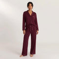 Stay In Society deep burgundy pajama set with long sleeves, notched collar, and satin piping on a female model.