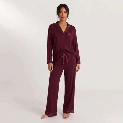 Stay In Society deep burgundy pajama set with long sleeves, notched collar, and satin piping on a female model.